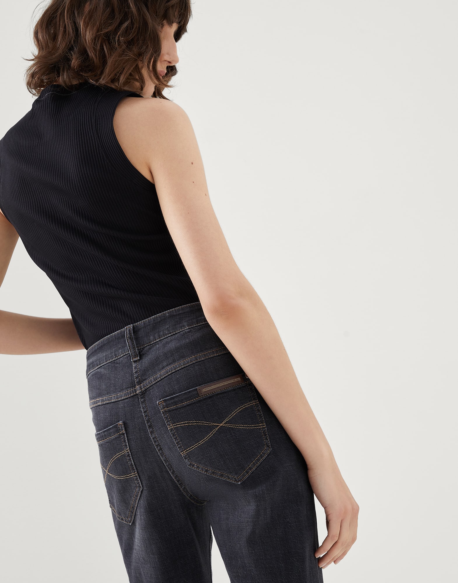Stretch denim slim trousers with shiny leather tab