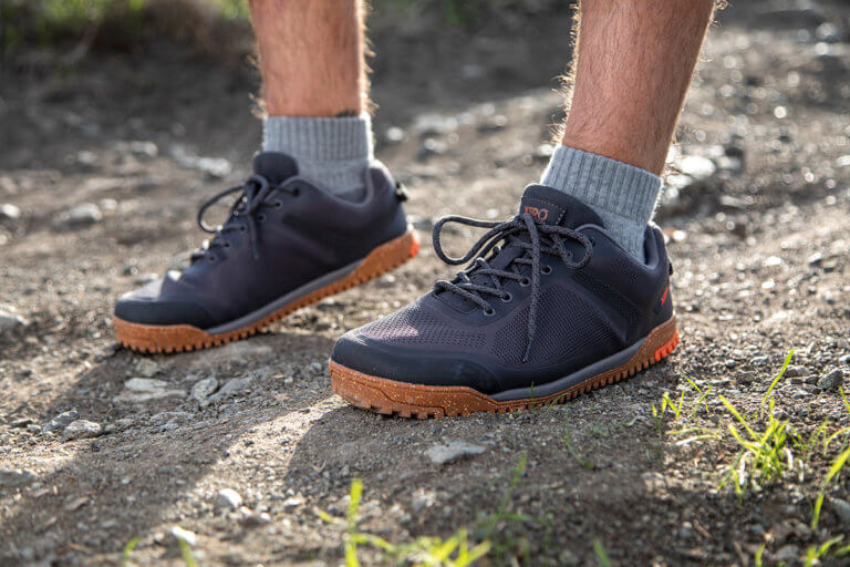 A close up shot of a man wearing Rideway Mesh Low shoes standing on the trail in the sun