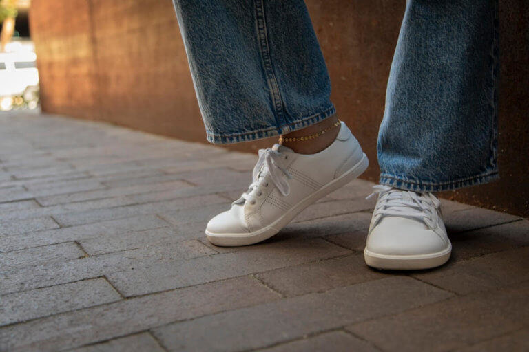 A woman standing in her Dillon Leather shoes with an ankle accessory and jeans.