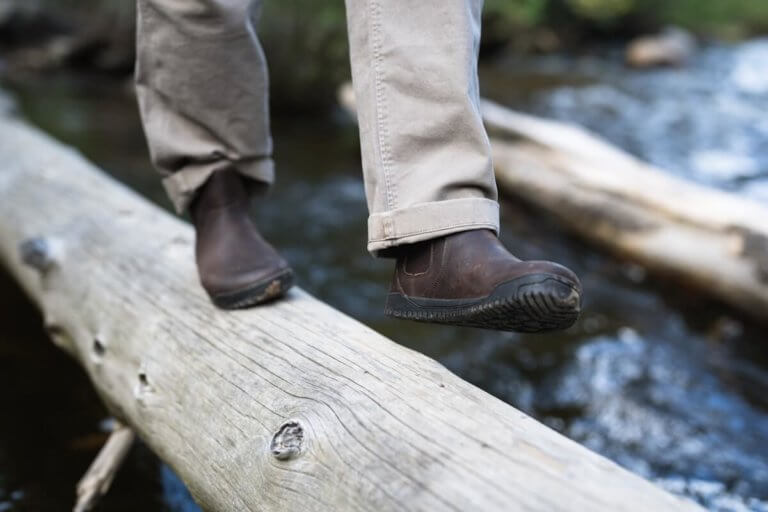 A person balancing on a log while walking in their Ridgeway Chelsea boots.