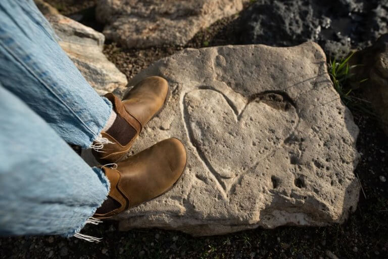 A woman in her Ridgeway Chelsea boots standing on a rock with a heart shape