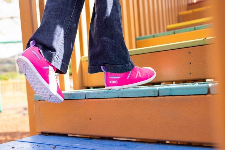 A girl running up wooden stairs in her Prio Youth shoes