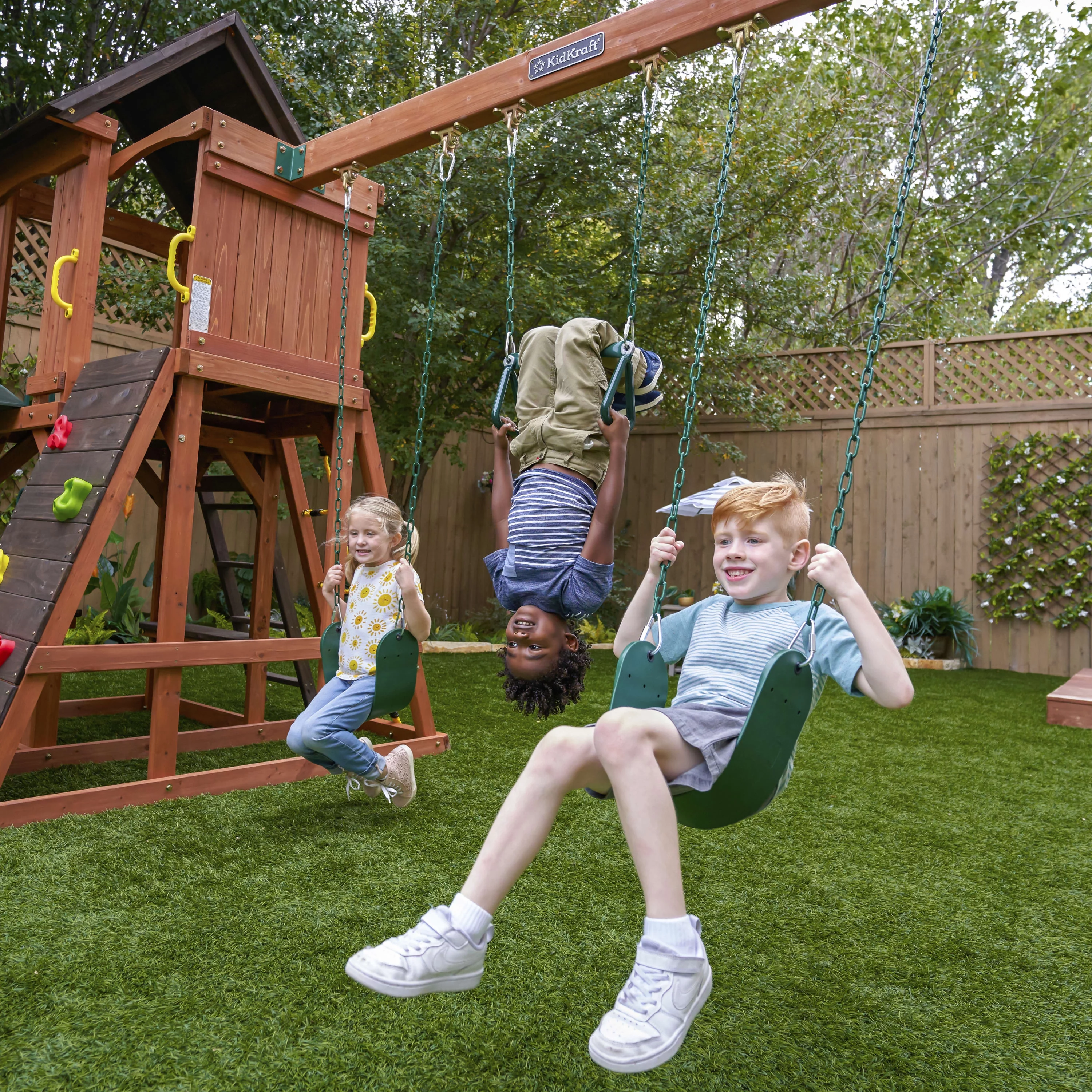 KidKraft Raptor Trail Wooden Outdoor Swing Set with Wavy Slide and Rock Wall, For Ages 3-10