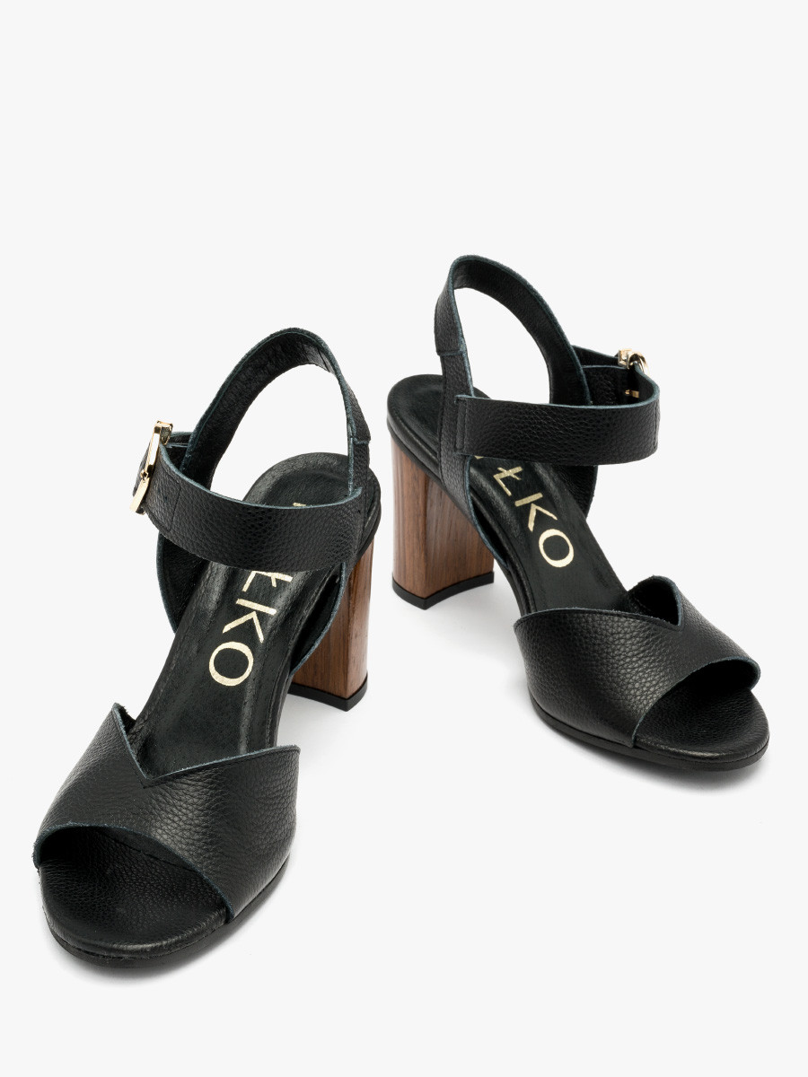 Czarne sanday na drewnianym supku