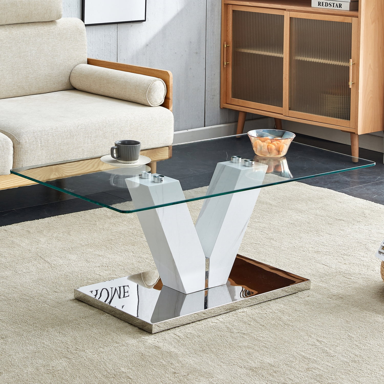 Sleek and contemporary modern coffee table featuring minimalist design. Clear tempered glass tabletop rests elegantly on sleek silver MDF pillars. Perfect addition to any modern living ro