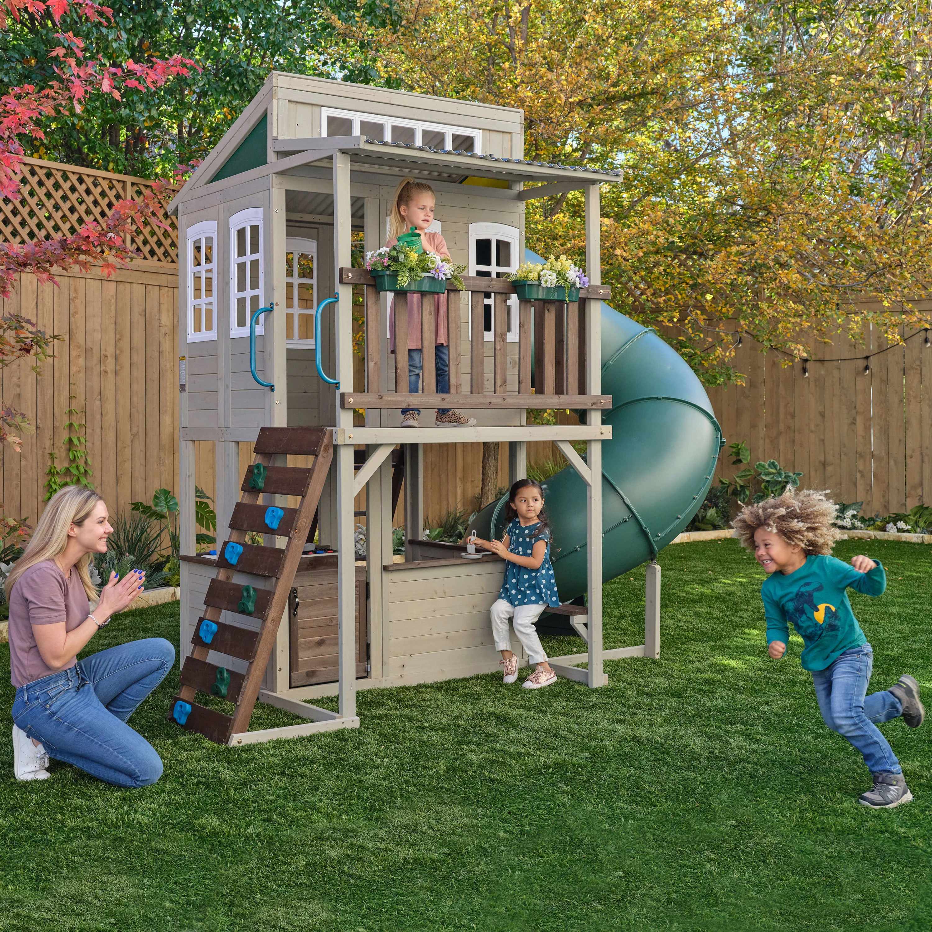 KidKraft Cozy Escape Wooden Outdoor Two-Story Playhouse with Slide, Kitchen, Rock Wall and Bench